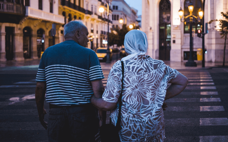 older couple holding hands crossing street