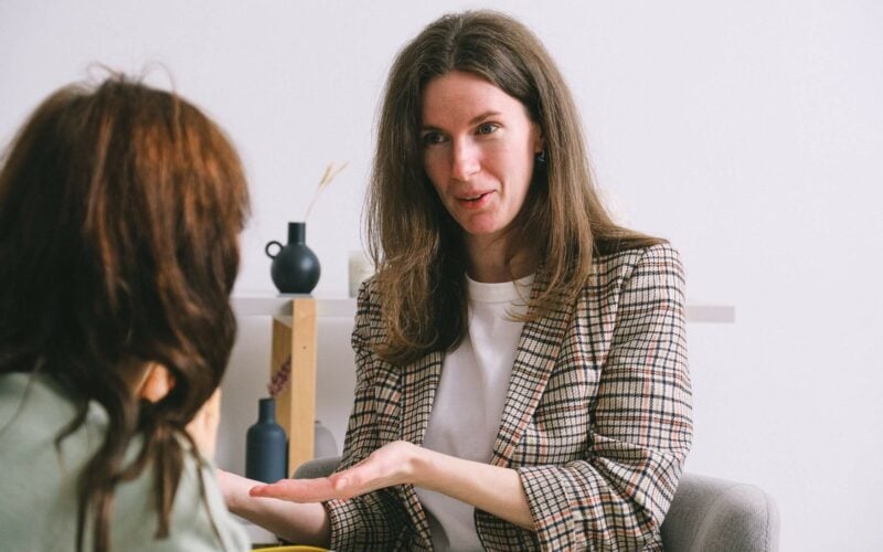 woman speaking to young woman motioning with hands