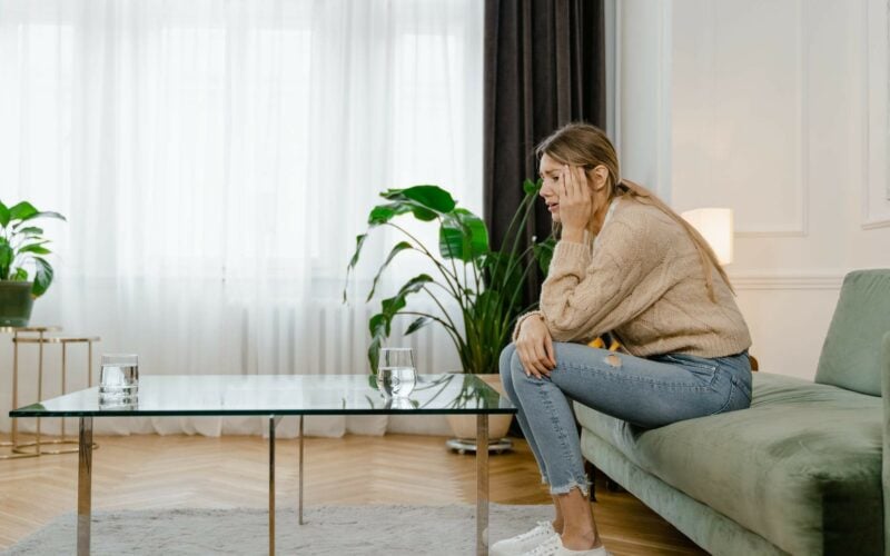 stressed out woman sitting on couch