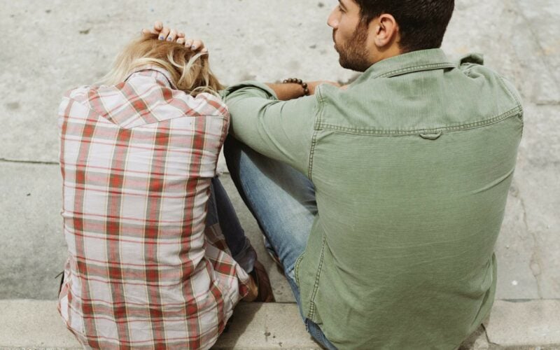 woman crouching down and man sitting next to her